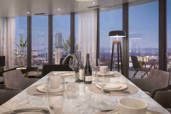 A close-up of a marble dining table set for dinner with wine bottles, positioned against floor-to-ceiling windows that showcase the illuminated city skyline at dusk, highlighting the apartment's prime location.