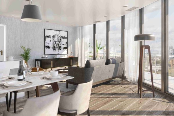 View of the open-concept living area showing high-quality wooden flooring, a modern white and grey kitchen in the background, and a cozy lounge space with a grey sofa and mustard accent chair.